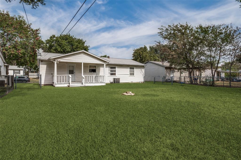 2528 Rugby Lane Farmers Branch, TX 75234 - Photo 12 of 12 Expansive lawn with a chain-link fence, mature trees, and a covered porch with white railings