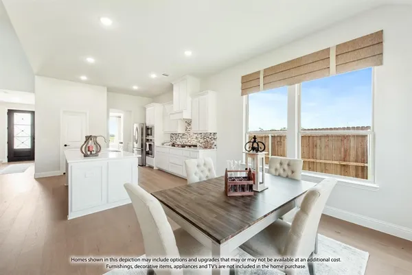 a dining hall with stainless steel appliances kitchen island granite countertop a dining table and chairs with wooden floor