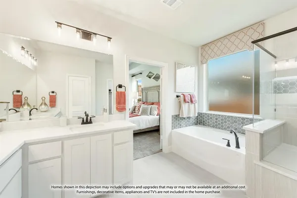 a en suite bathroom with a tub double sink window and mirror