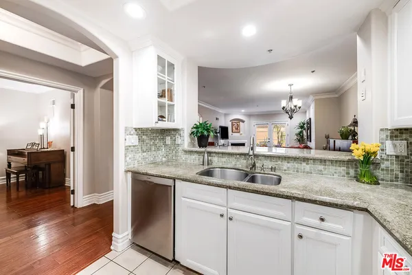 a kitchen with granite countertop a sink and cabinets