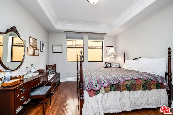 a bedroom with a bed a dresser and window