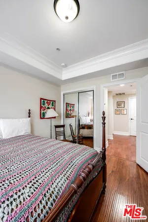 a bedroom with a large bed and a chandelier