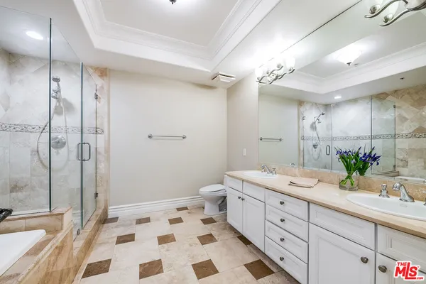 a spacious bathroom with a double vanity sink a toilet and a shower