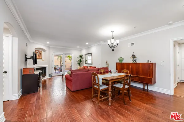 a view of a dining room with furniture a rug and wooden floor