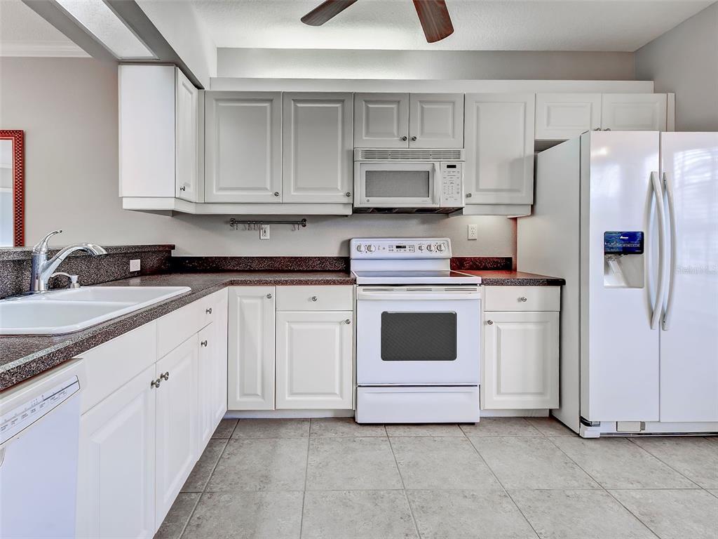 902 Addington Court, Unit 103 Venice, FL 34293 - Photo 15 of 48 a kitchen with white cabinets and white appliances