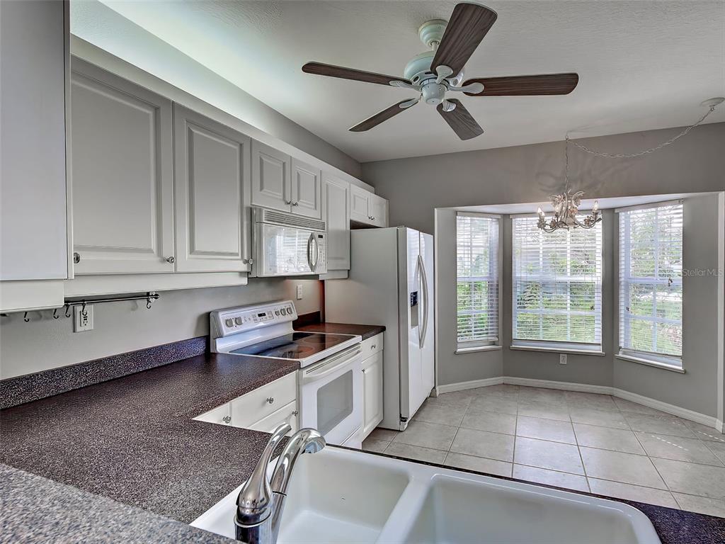 902 Addington Court, Unit 103 Venice, FL 34293 - Photo 16 of 48 a kitchen with stainless steel appliances granite countertop a refrigerator and a stove top oven
