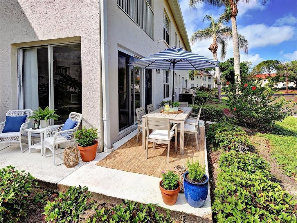902 Addington Court, Unit 103 Venice, FL 34293 - Photo 33 of 48 a view of a patio with table and chairs potted plants