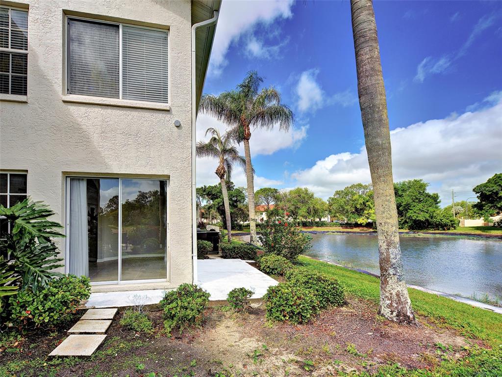 902 Addington Court, Unit 103 Venice, FL 34293 - Photo 37 of 48 a front view of a house with lake view and a floor to ceiling window next to a yard