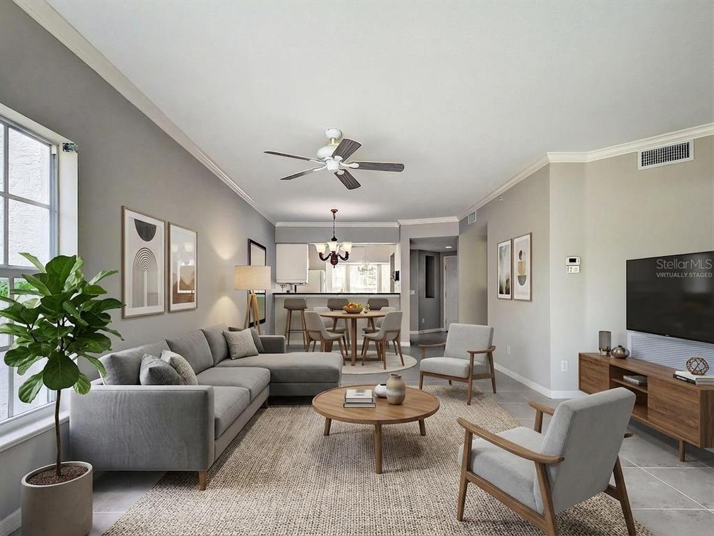 902 Addington Court, Unit 103 Venice, FL 34293 - Photo 6 of 48 a living room with furniture a chandelier and a flat screen tv