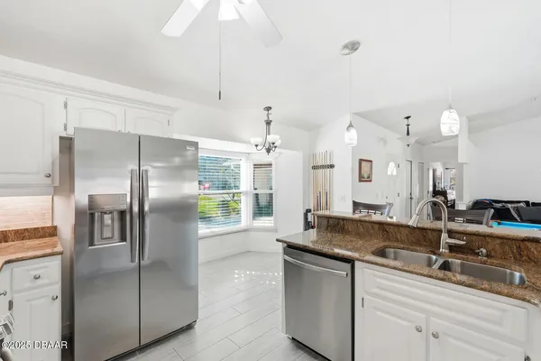 a kitchen with stainless steel appliances granite countertop a sink a refrigerator and a granite counter tops