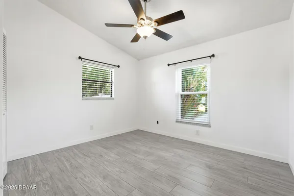 a view of an empty room with a window and a ceiling fan