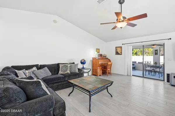 a living room with furniture a ceiling fan and a wooden floor