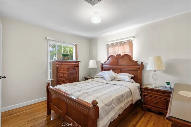 a bedroom with a bed and wooden floor
