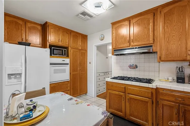 a kitchen with stainless steel appliances granite countertop a sink a stove and refrigerator