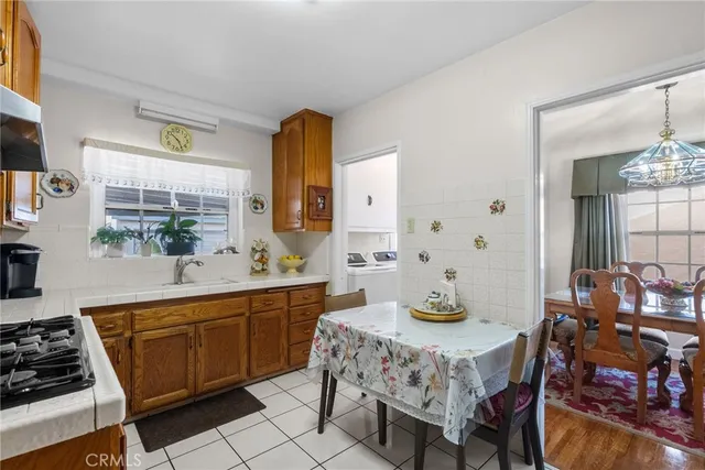 a kitchen with a stove a sink and a dining table with chairs