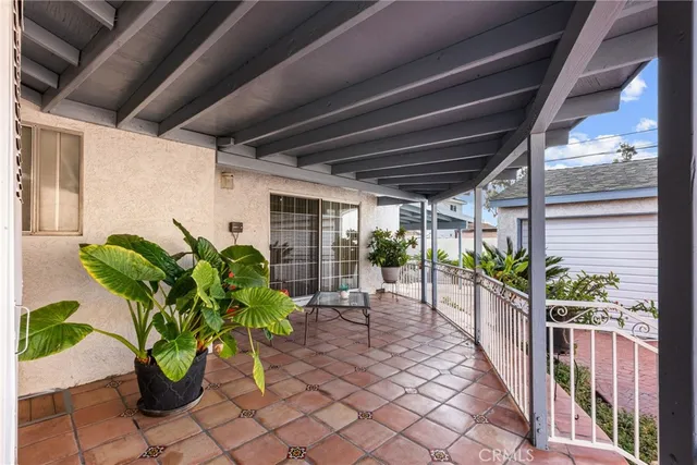 a view of a porch with chairs and potted plants