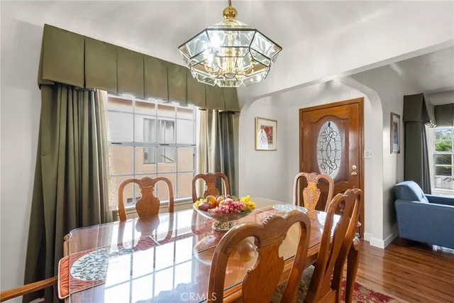 a view of a dining room with furniture a chandelier and wooden floor