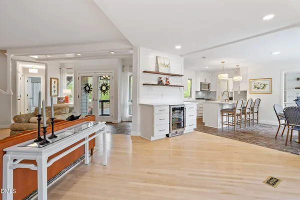 a large white kitchen with stainless steel appliances kitchen island granite countertop a large center island and a stove top oven