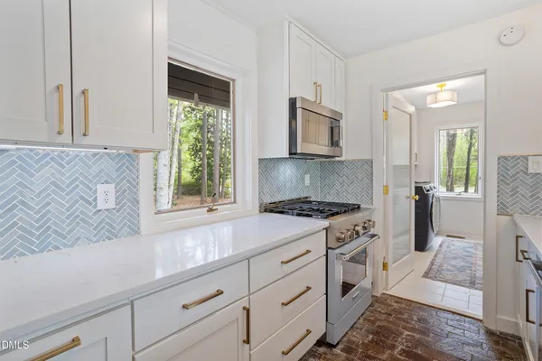 a kitchen with a stove a sink and a window