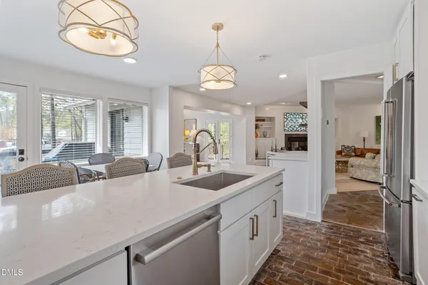 a view of a kitchen island a chandelier furniture and windows