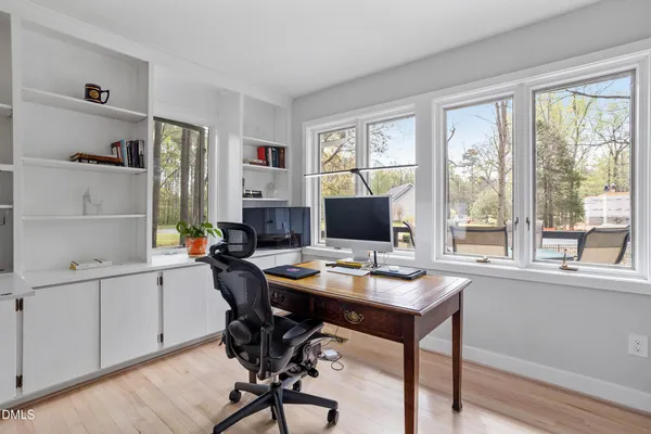 a view of a workspace with furniture and a window