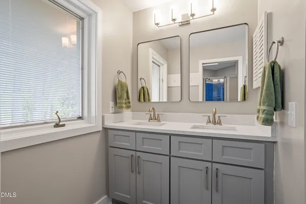a bathroom with a double vanity sink and a mirror