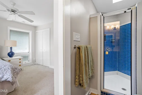 a bedroom with a bed and a glass walk in closet