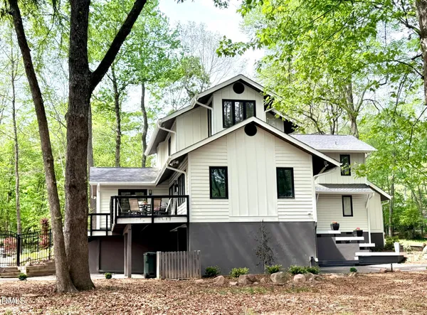a view of a house with large windows and a small yard