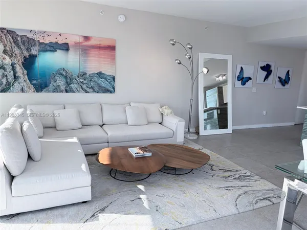 a living room with furniture and a painting on the wall
