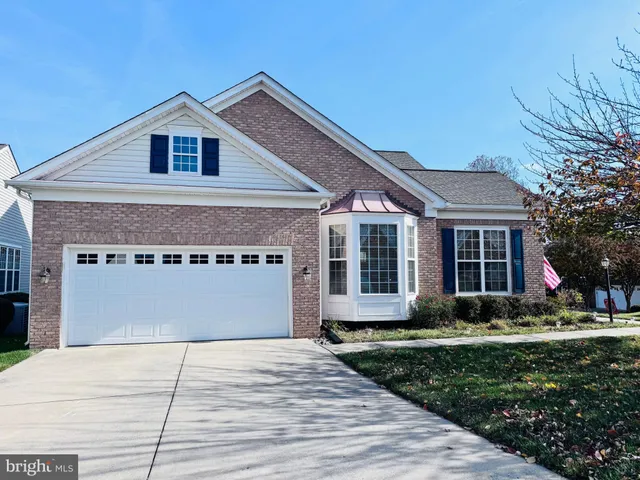 a front view of a house with a garden and yard
