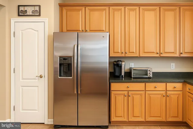 a kitchen with granite countertop a refrigerator and cabinets