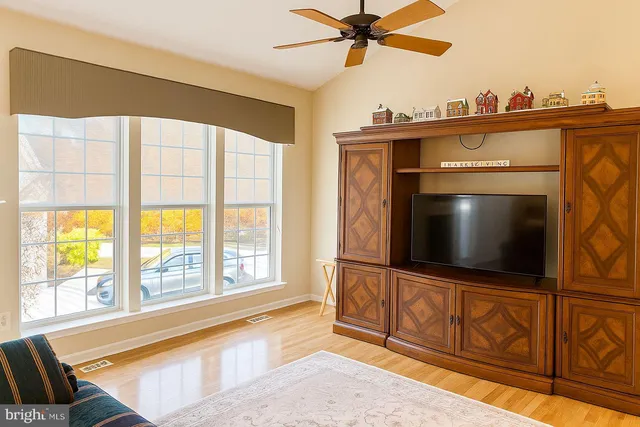 a living room with a fireplace television and a large window