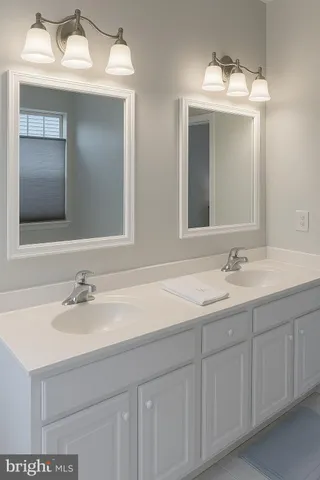 a bathroom with double sink and a mirror
