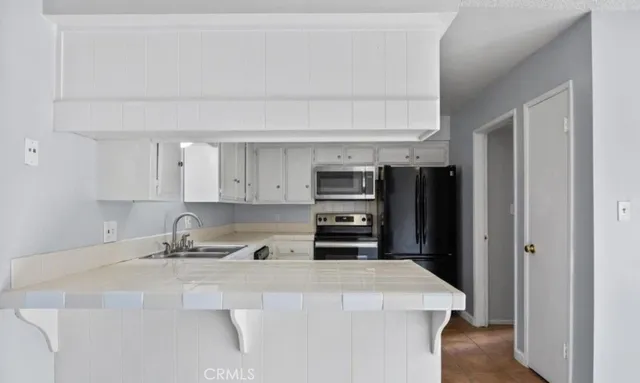 a kitchen with stainless steel appliances a refrigerator a sink a stove and cabinets