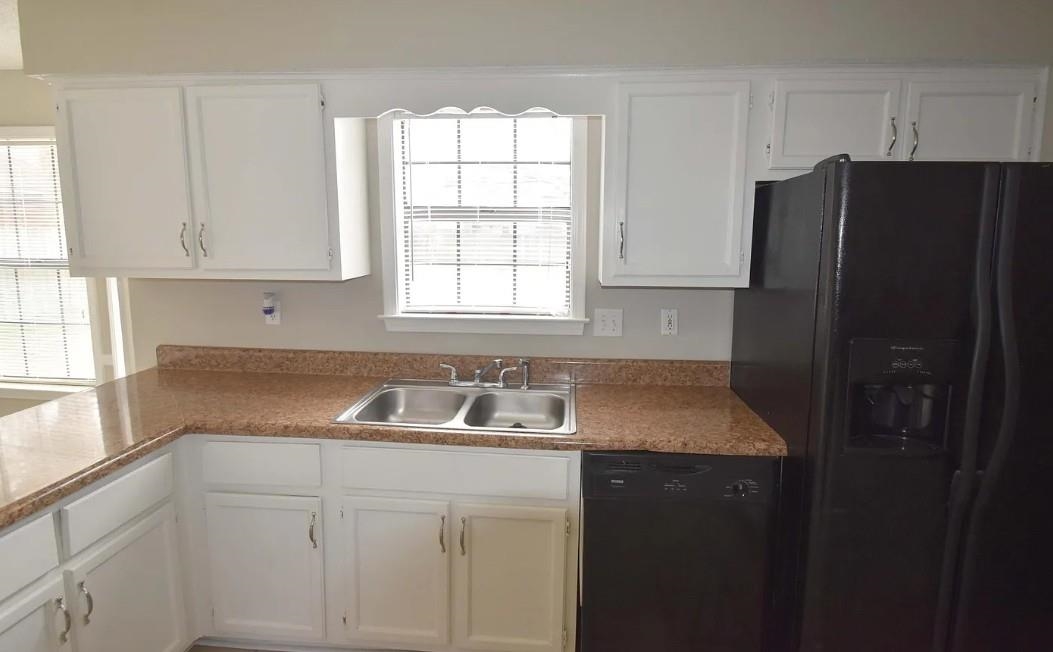 7605 Reese Road Memphis, TN 38133 - Photo 2 of 11 a kitchen with granite countertop white cabinets and refrigerator