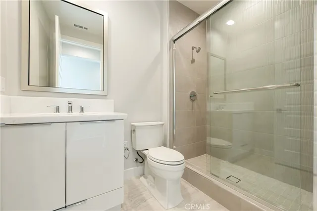 a bathroom with a shower sink vanity and toilet