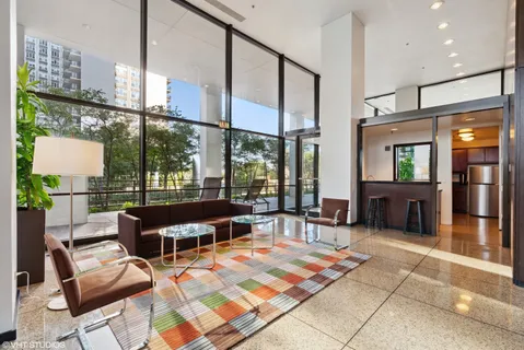 a living room with patio furniture and a floor to ceiling window