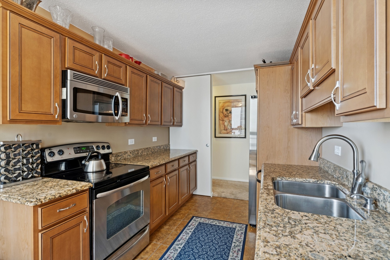 360 East Randolph Street, Unit 1208 Chicago, IL 60601 - Photo 8 of 27 a kitchen with granite countertop a stove and a sink