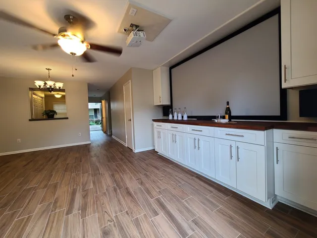 a view of a kitchen with a sink dishwasher wooden floor and cabinets