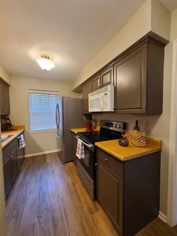 a kitchen with stainless steel appliances granite countertop a sink stove and wooden floor