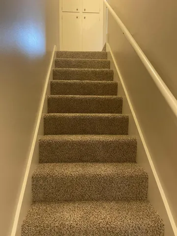 a white toilet sitting next to a white wall