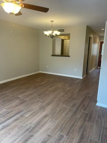 an empty room with wooden floor and mirror