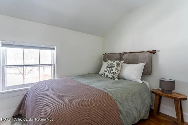 a large bed sitting in a bedroom next to a window