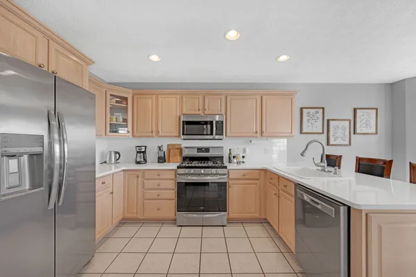 a kitchen with stainless steel appliances granite countertop a refrigerator sink and stove