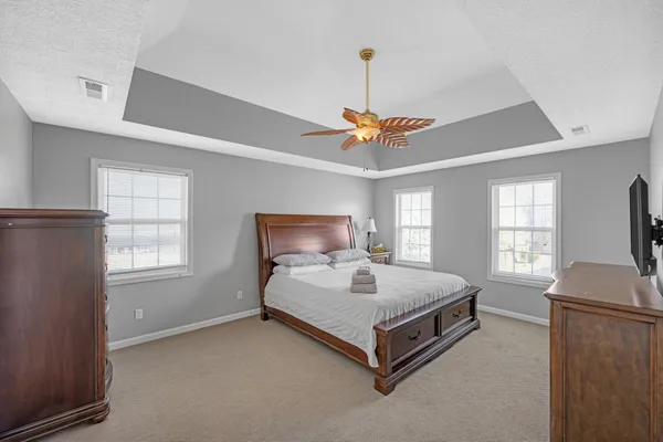 a spacious bedroom with a bed and a chandelier