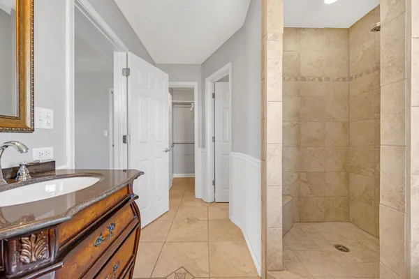 a spacious bathroom with a sink a mirror and a shower