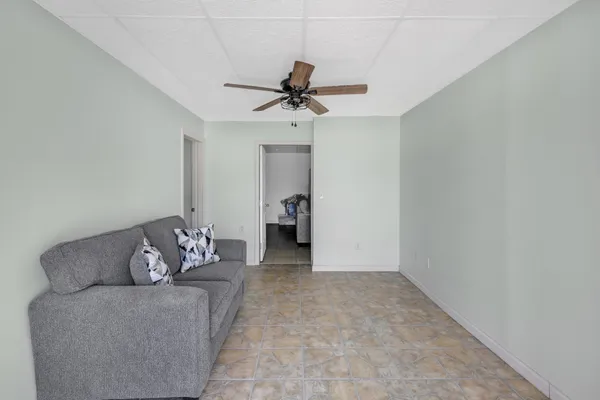 a living room with furniture and a ceiling fan