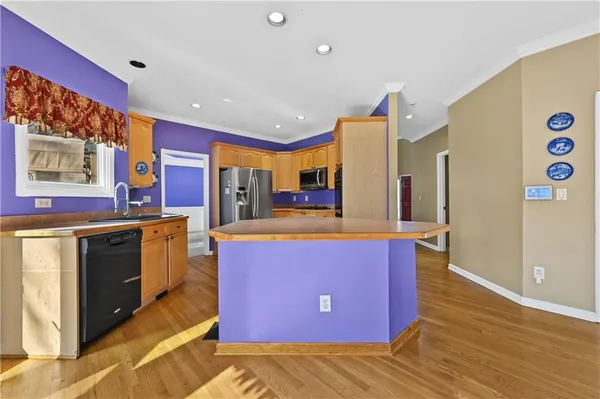 a kitchen with stainless steel appliances granite countertop a sink and a refrigerator