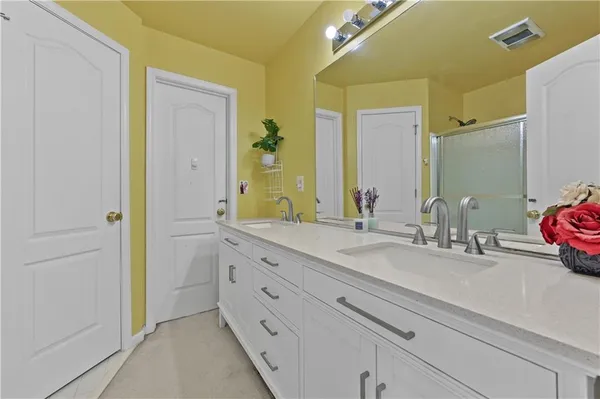 a bathroom with a double vanity sink a mirror and a shower