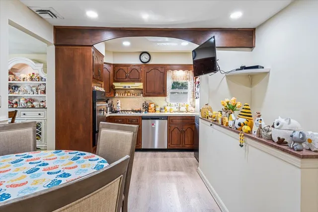 a kitchen with stainless steel appliances kitchen island granite countertop a sink stove and refrigerator